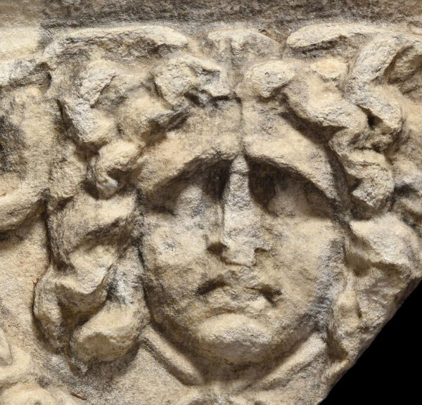 Roman fragment of sarcophagus depicting a Gorgon and Eros with libertus Marcus Aurelius epitaph